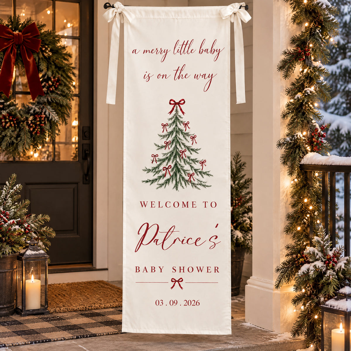 Personalized Christmas baby shower banner on a snowy porch with a wreath, candle lanterns and lit garland