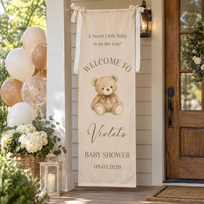 Personalized Baby Shower Welcome Backdrop with teddy bear design hung on a porch near balloons, flowers and a wooden door