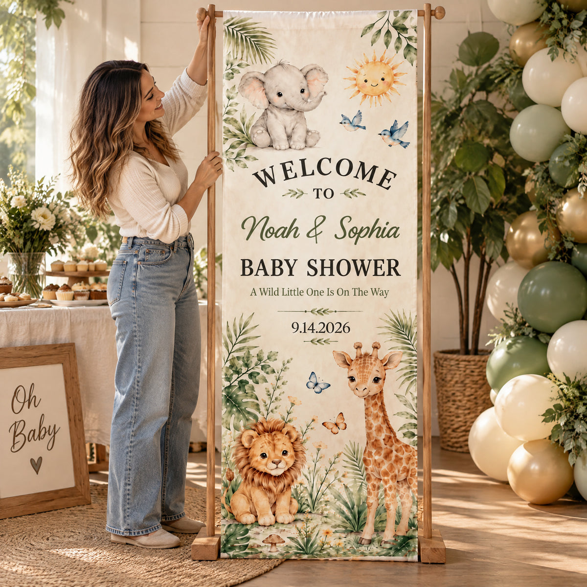 Personalized Safari Baby Shower Banner on a wooden stand with a woman holding it beside balloons and a sign