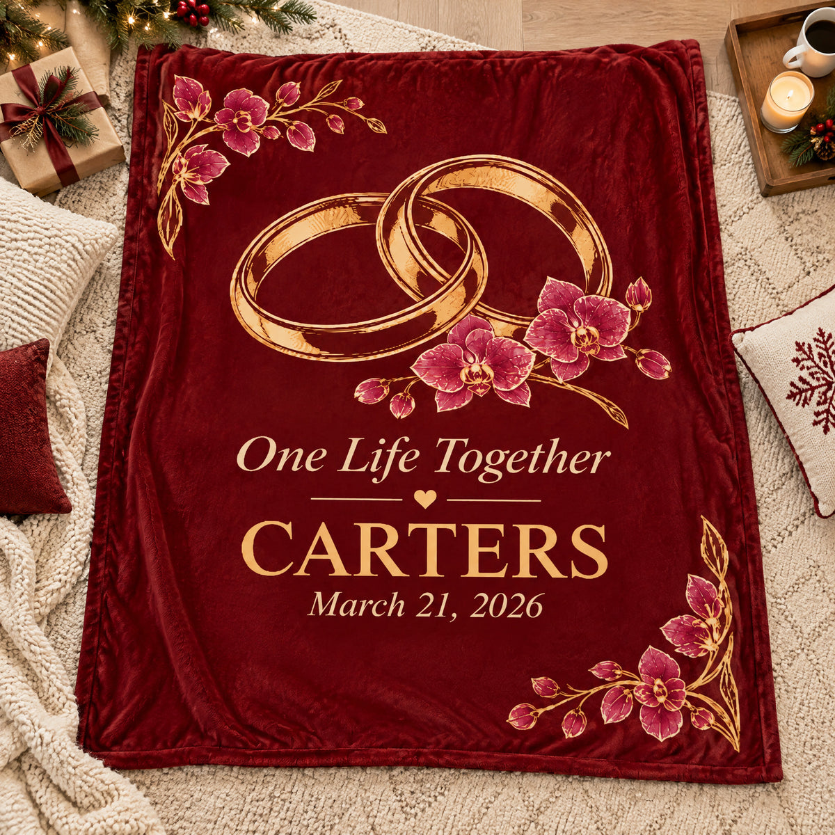 Personalized wedding rings blanket laid flat on a cream rug with gift, candle, tray and holiday pillows nearby