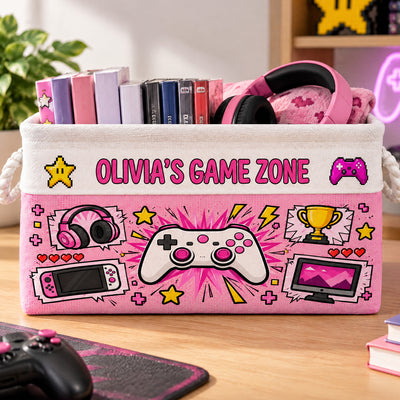 Personalized Game Zone Storage Basket in pink with headphones, game cases and a controller graphic on a wooden desk