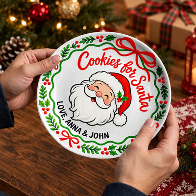 Personalized Cookies For Santa Ceramic Round Plate held in two hands near a Christmas tree and wrapped gift