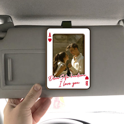 Personalized Car Visor Clip clipped to a gray sun visor, held by a hand, showing a couple photo and red script text