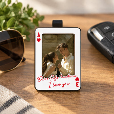 Personalized Car Visor Clip standing on a wooden table beside sunglasses, a car key fob and green leaves