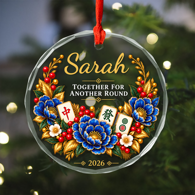Personalized glass ornament with mahjong hanging on a tree, Sarah name, blue flowers, red berries and 2026