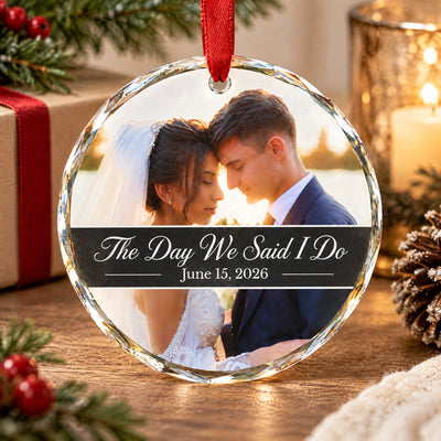 Personalized glass ornament custom photo standing on a wooden table near a candle, gift and pinecone