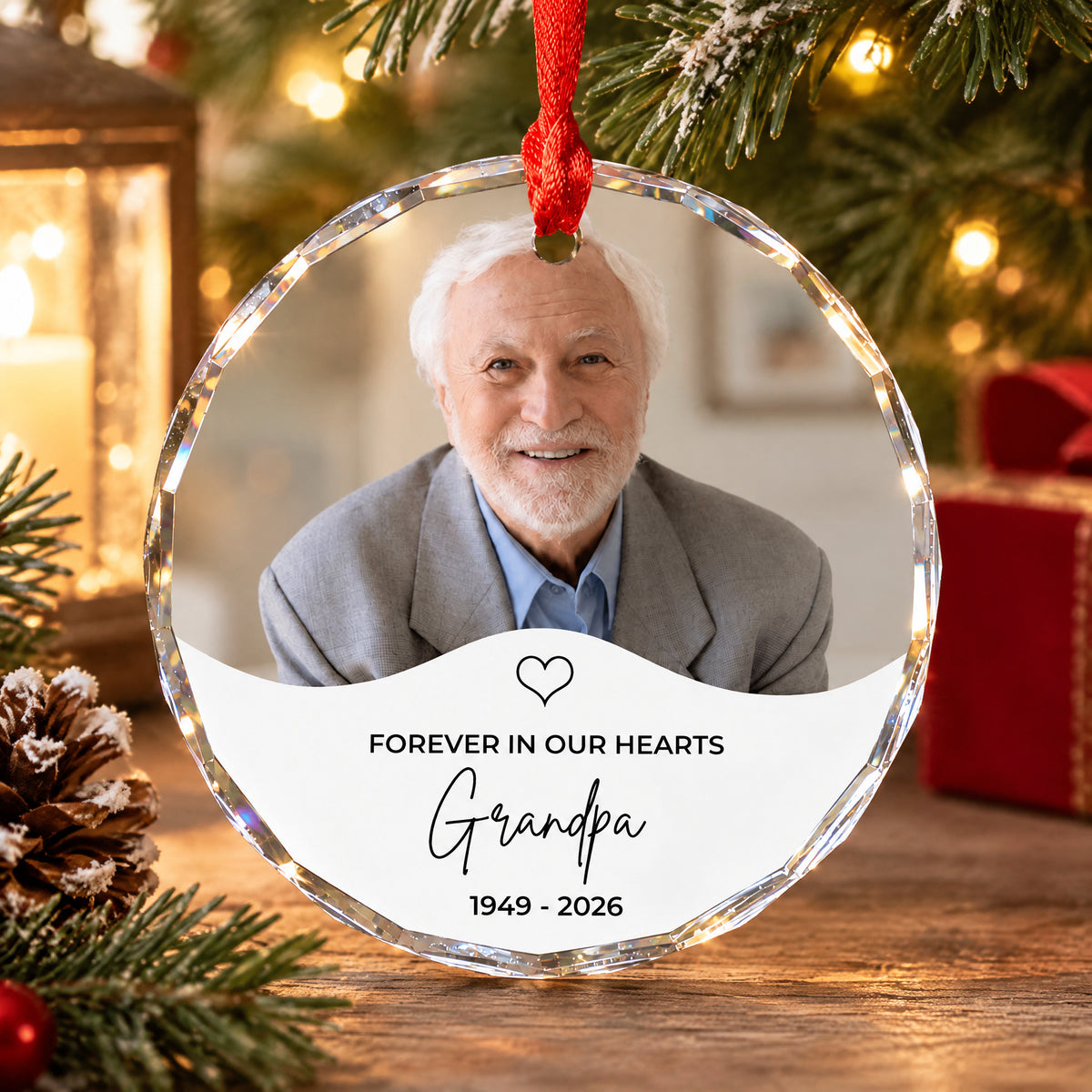 Personalized glass ornament custom photo with grandpa portrait resting on a wooden table by a pinecone and gift