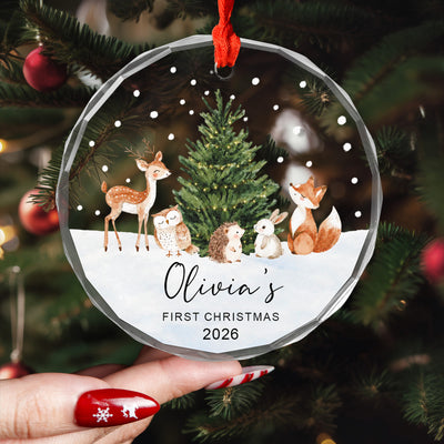 Personalized Woodland Animals Glass Ornament held in a hand with red nails in front of a decorated tree