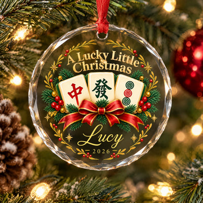 Personalized glass ornament mahjong tile close view with faceted edge, pinecone and a red bauble beside it on the tree