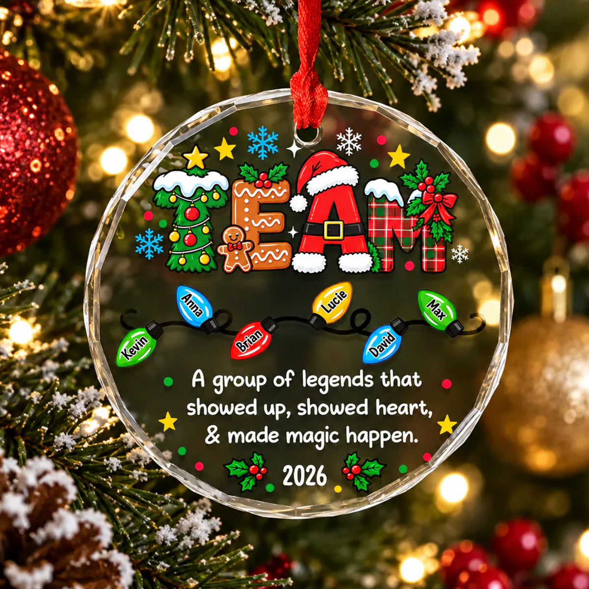 Personalized glass ornament custom team hanging on a tree branch with red baubles and a pinecone nearby