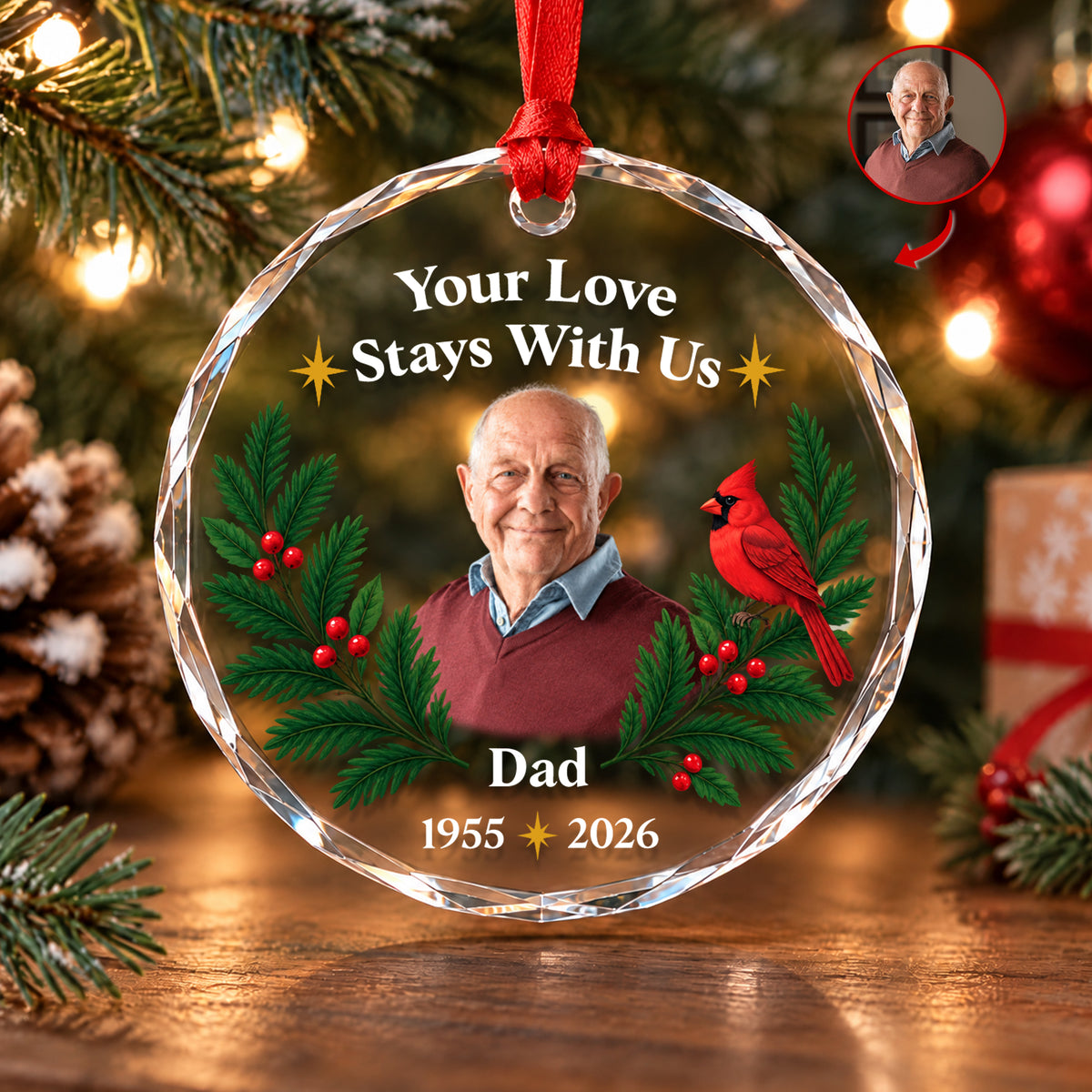Personalized glass ornament custom photo with cardinal and holly, hanging by a red ribbon near pine branches and lights