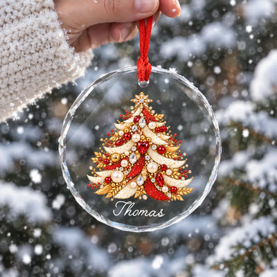 Personalized Christmas Tree Glass Ornament held in a hand against snowy pine branches, red jeweled tree with name