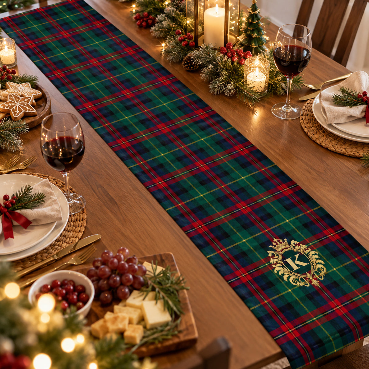 Personalized Christmas table runner in green and red plaid with gold monogram, set with wine glasses and cheese board