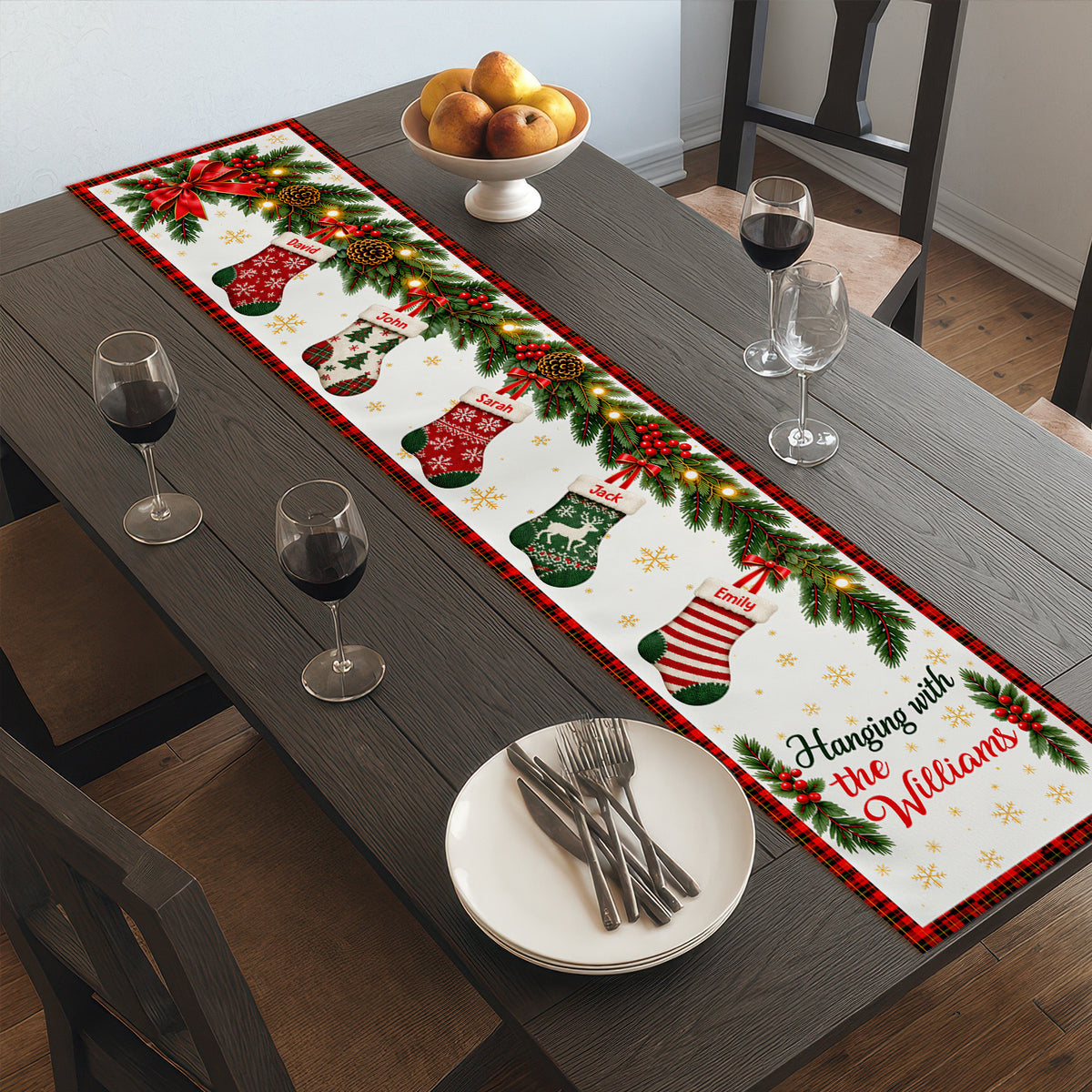 Custom family name stockings table runner on a dark table with wine glasses, a bowl of pears and stacked plates