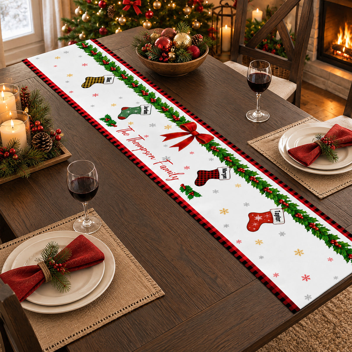 Personalized Christmas table runner on a dark table with woven placemats, red napkins and an ornament bowl