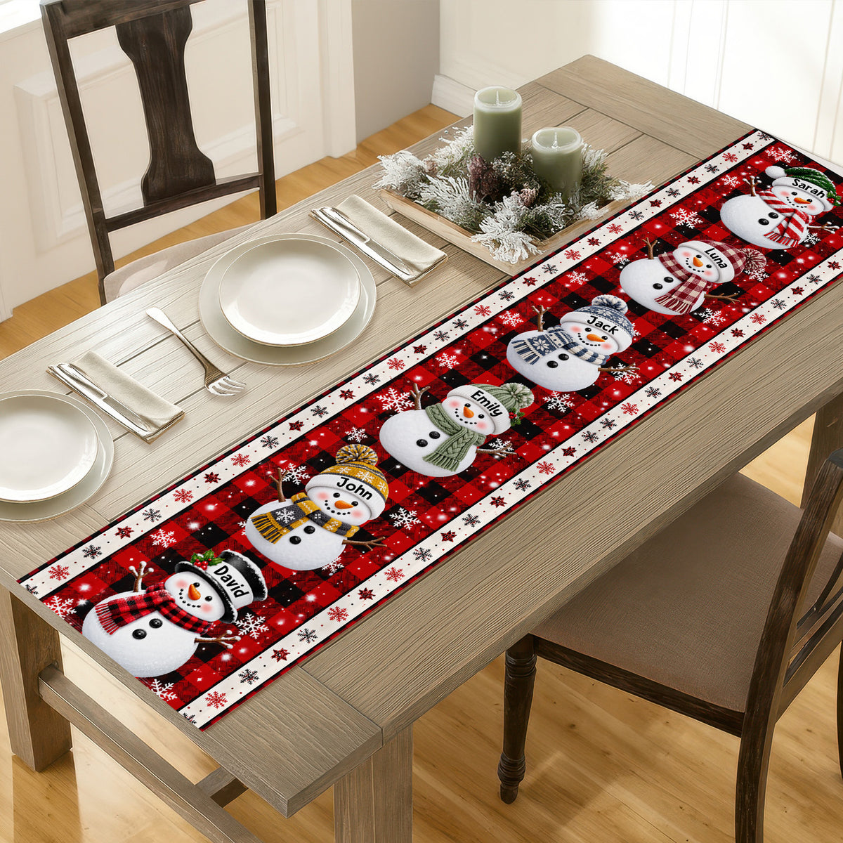 Personalized Snowman Family Christmas Table Runner on a wooden dining table with plates, napkins and candles