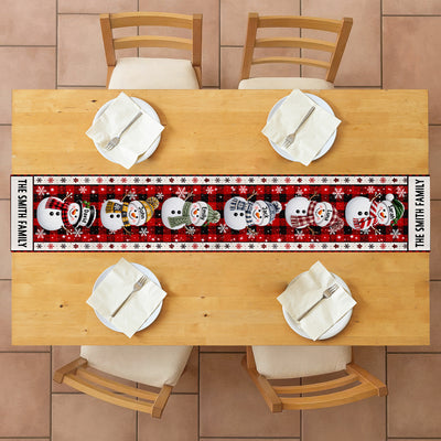 Personalized Snowman Family Christmas Table Runner seen from above on a table set for four with folded napkins