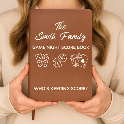 Personalized leather journal game night score held upright in both hands by a person in a cream sweater