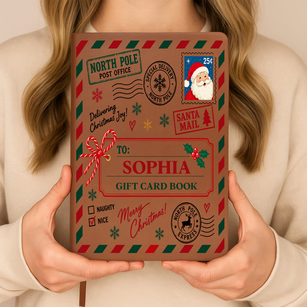 Personalized North Pole Santa Mail Leather Journal held upright by a woman in a cream sweater, name Sophia on cover