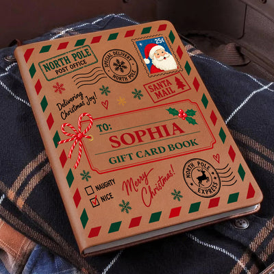 Personalized North Pole Santa Mail Leather Journal lying at an angle on a dark plaid shirt
