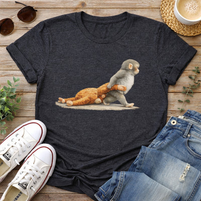 Dark gray t-shirt with a graphic of a monkey and bear, placed on a wooden surface with shoes and jeans around.