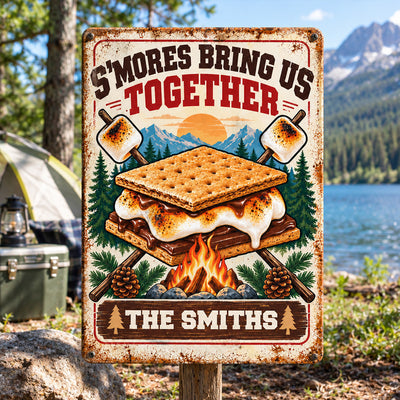 Personalized metal sign S'mores Bring Us Together on a post by a camping tent, cooler and lake