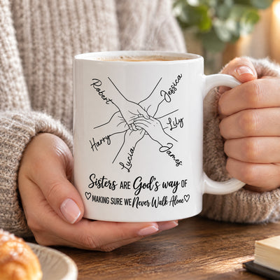 Personalized Sisters Name Mug with clasped hands design beside a vase of white flowers and a lit candle