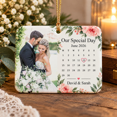 Personalized rectangular ceramic ornament hanging on a lit Christmas tree with a couple photo and June calendar