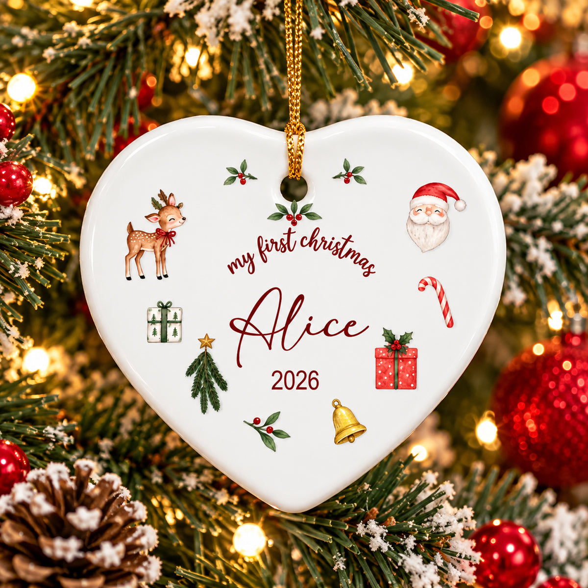 Personalized First Christmas Ceramic Ornament heart shape hanging on a snowy tree with red baubles and lights