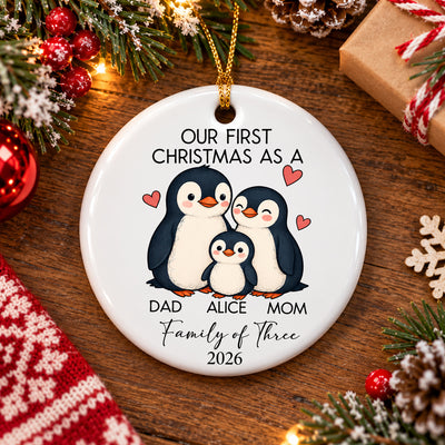 Personalized Ceramic Family Ornament lying on a wooden table with pine branches, a wrapped gift and a knit cloth