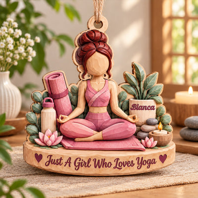 Personalized yoga wood ornament with meditating figure, yoga mat, lotus flowers and candle on a table by a sunny window