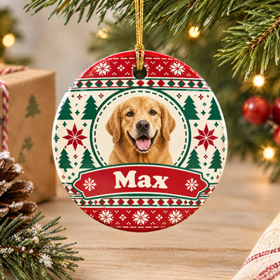 Personalized ceramic ornament custom photo name hanging in front of a wrapped gift and tree on a wooden surface