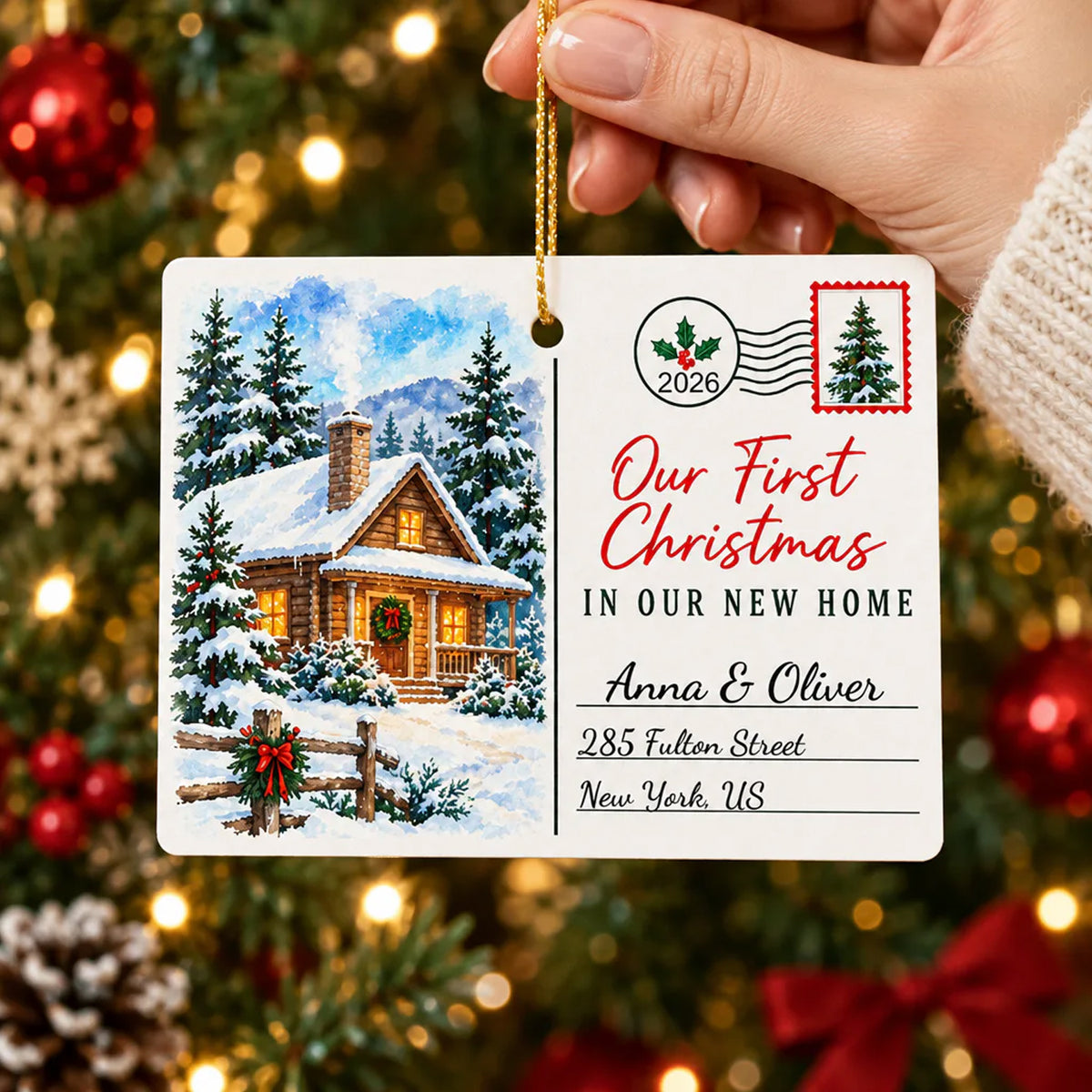 Personalized Rectangular Ceramic Christmas Ornament held by a hand in front of a lit tree with red baubles