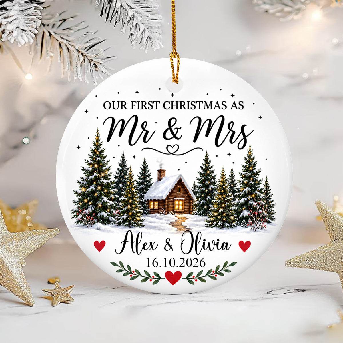 Personalized Ceramic Ornament Engaged Couple Gift round ornament beside gold stars and frosted branches on a white surface