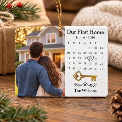 Personalized Rectangular Ceramic Ornament standing on a wooden table near a wrapped gift and knit blanket