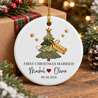 Personalized ceramic ornament First Christmas Married by a wrapped gift with plaid ribbon on a wooden table