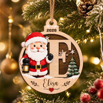 Personalized Santa Initial Wooden Ornament hanging on a lit Christmas tree, letter E with the name Elisa and 2026