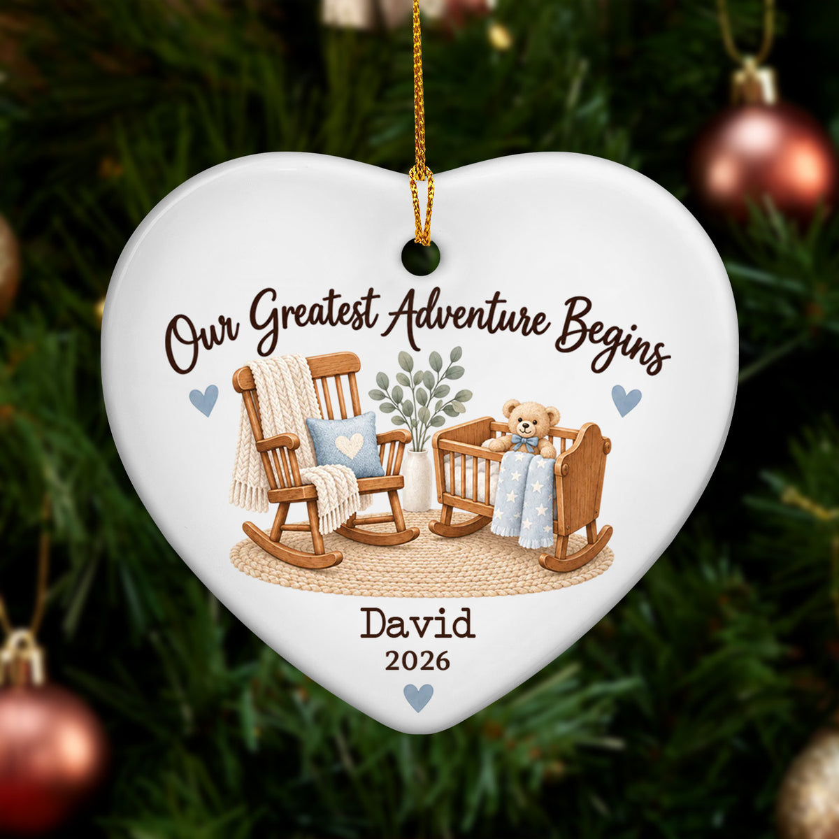 Personalized Ceramic Ornament Our Greatest Adventure Begins heart with blue design hanging on a pine tree