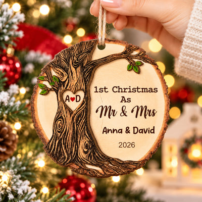 Personalized Wooden Ornament 1st Christmas Mr & Mrs held by a hand in front of tree lights, names Anna & David