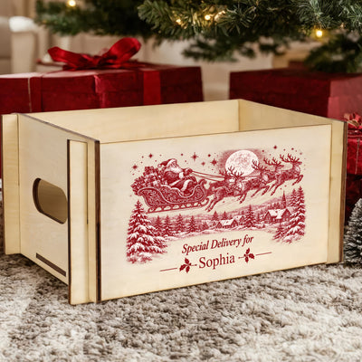 Personalized Christmas Eve Box shown empty from the side with a handle cutout, red gifts and tree behind it