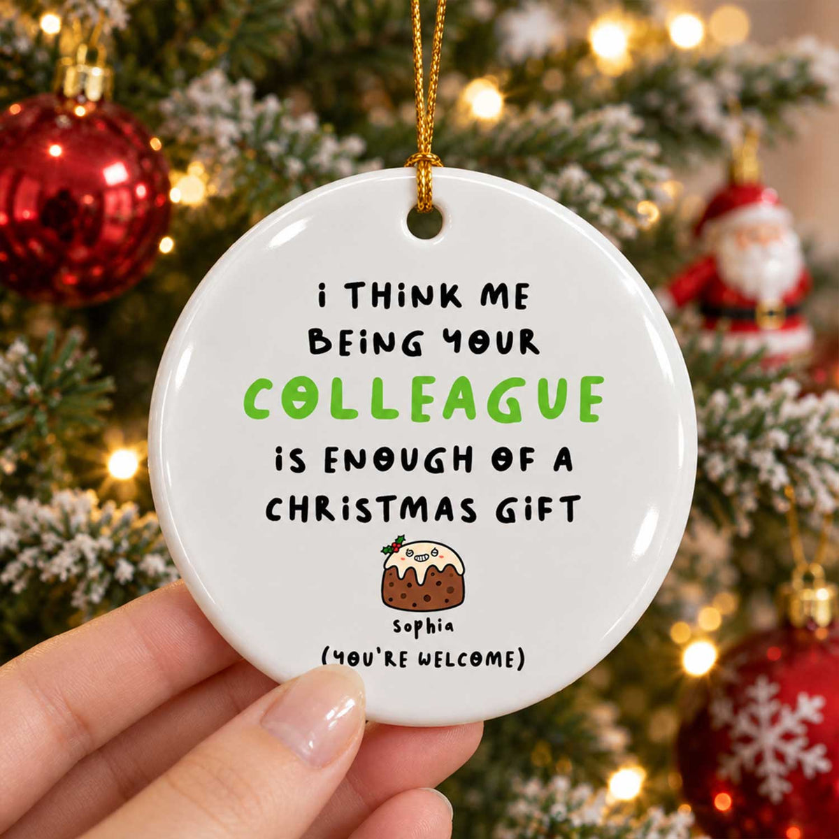 Personalized Colleague Christmas Gift Ceramic Ornament held in a hand, one pudding character, tree and Santa behind