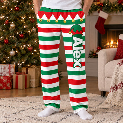Personalized Elf Pajama Pants worn by a man by a Christmas tree, name Alex down the leg