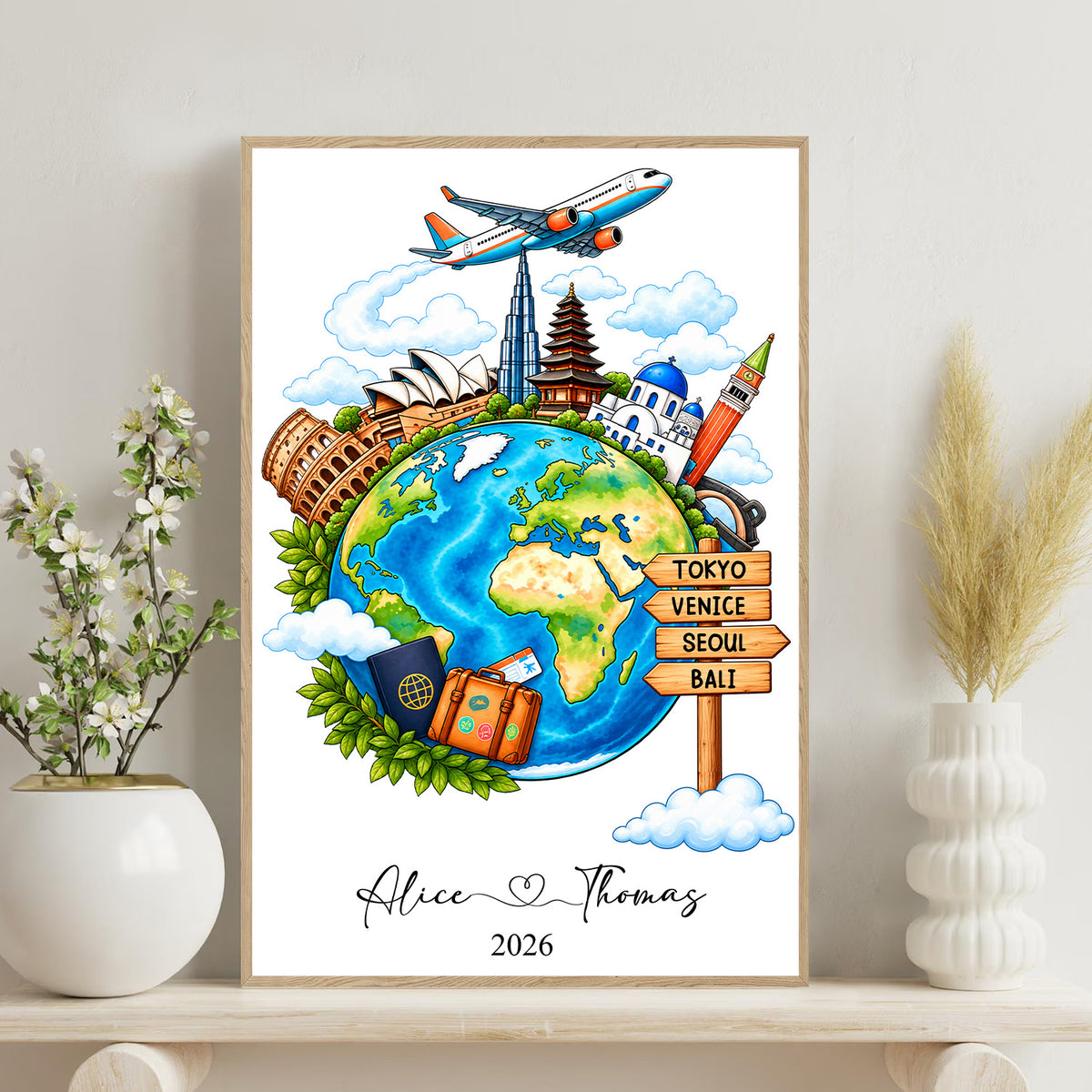 Watercolor travel globe personalized poster in a light wood frame on a shelf beside a vase and flowering branch
