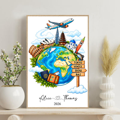 Watercolor travel globe personalized poster in a light wood frame on a shelf beside a vase and flowering branch