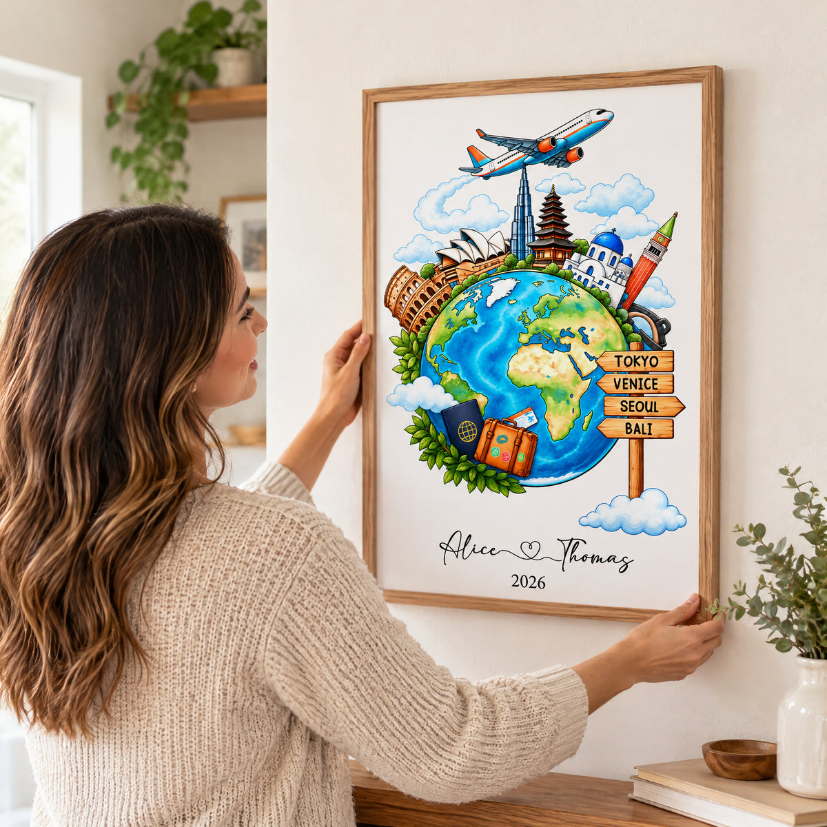 Watercolor travel globe personalized poster held by a woman as she hangs the framed print on a wall