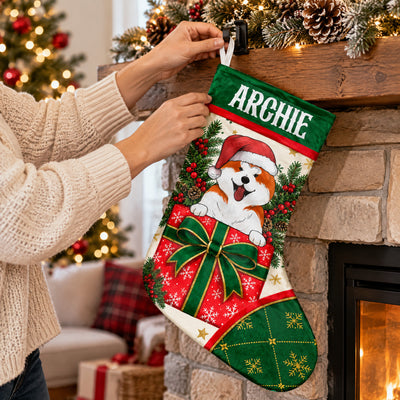 Personalized Christmas stocking with dog being hung on a stone fireplace mantel by hands in a cream sweater