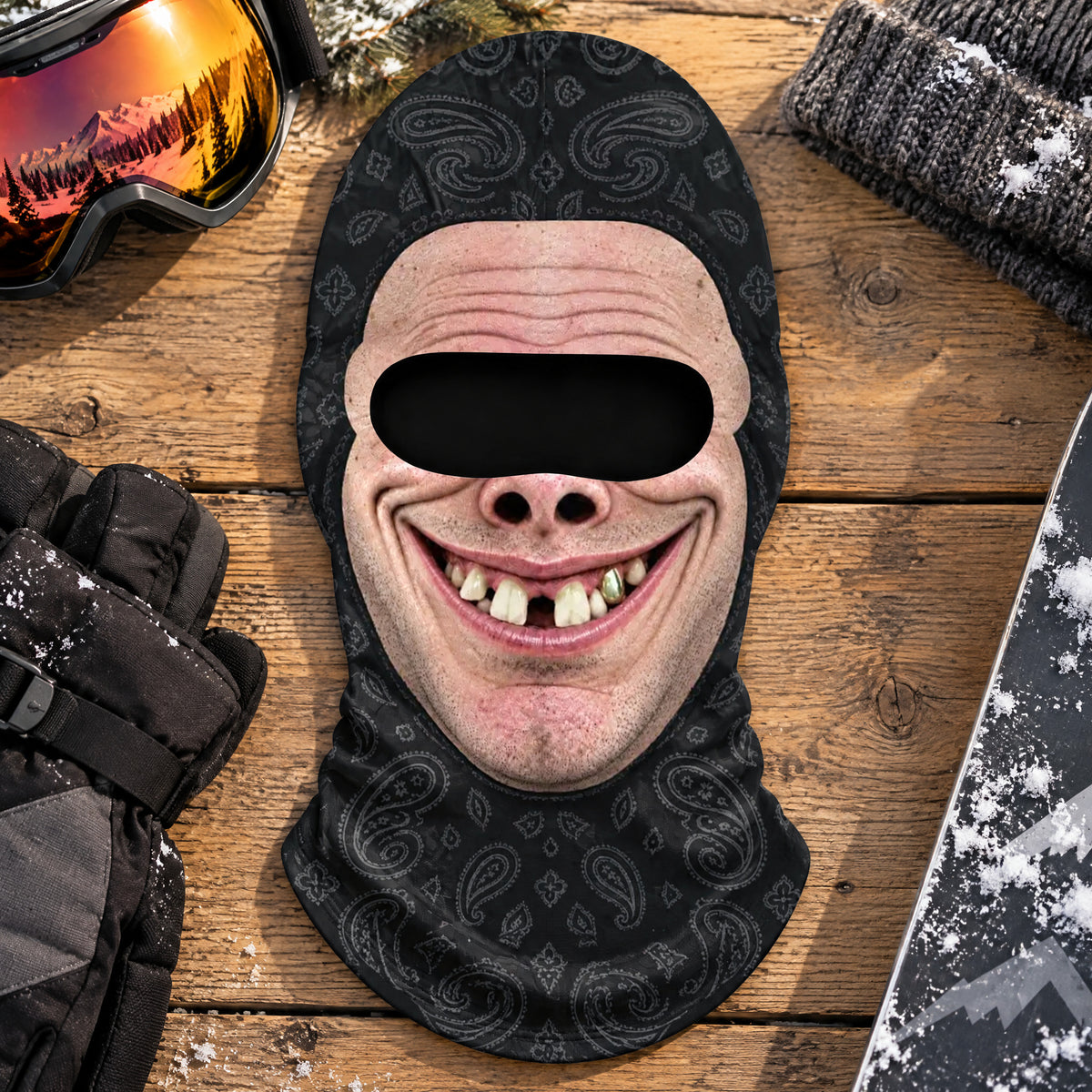 Funny Personalized Ski Mask on wood boards beside ski goggles, black gloves, a knit beanie and a snowboard