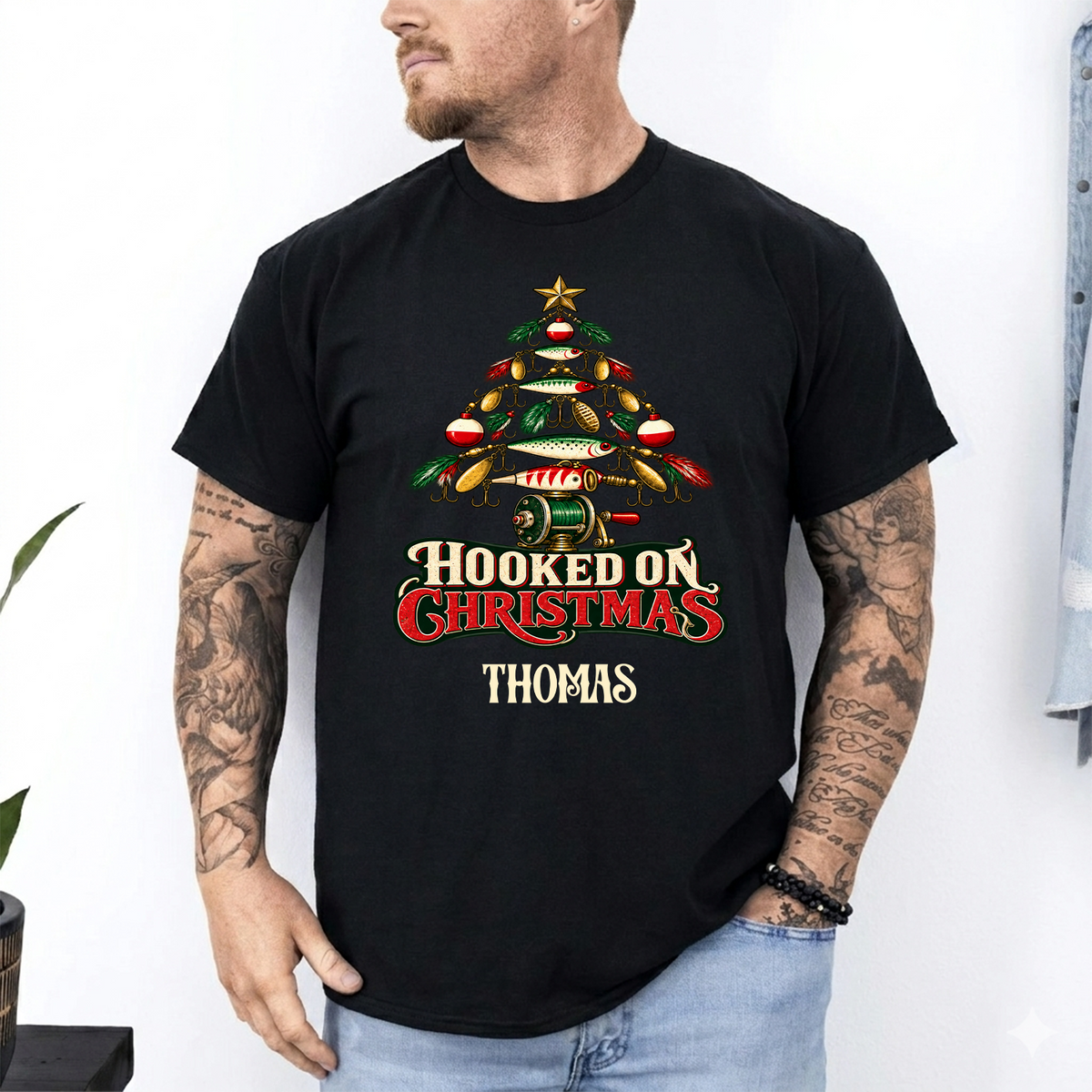 Hooked On Christmas Personalized Shirt in black worn by a tattooed man, fishing lure tree and name Thomas