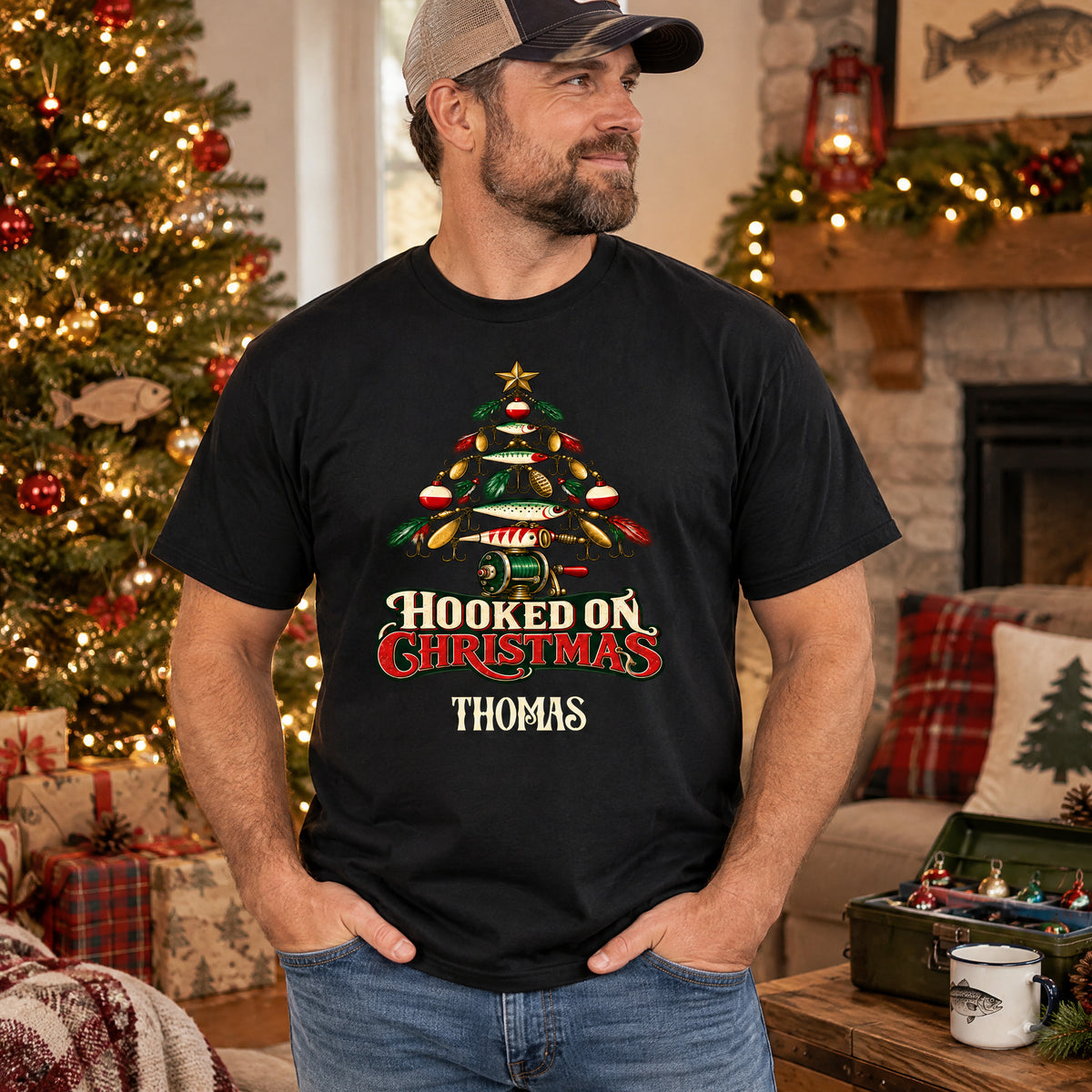 Hooked On Christmas Personalized Shirt in black worn by a man in a cap near a Christmas tree and fireplace