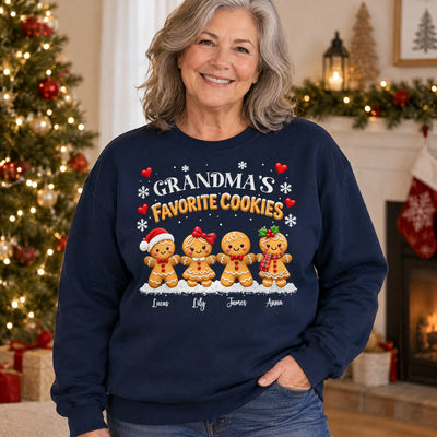 Personalized Grandma's Favorite Cookies Sweatshirt worn by a smiling woman beside a Christmas tree and fireplace